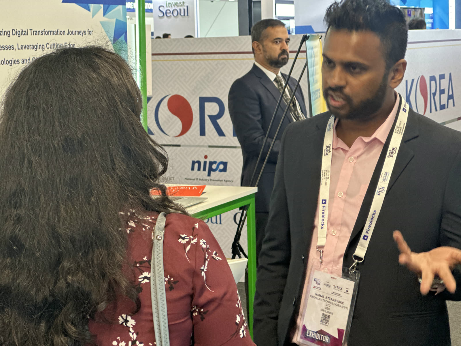 Namal Attanayake speaking with a visitor in the exhibition hall in Dubai