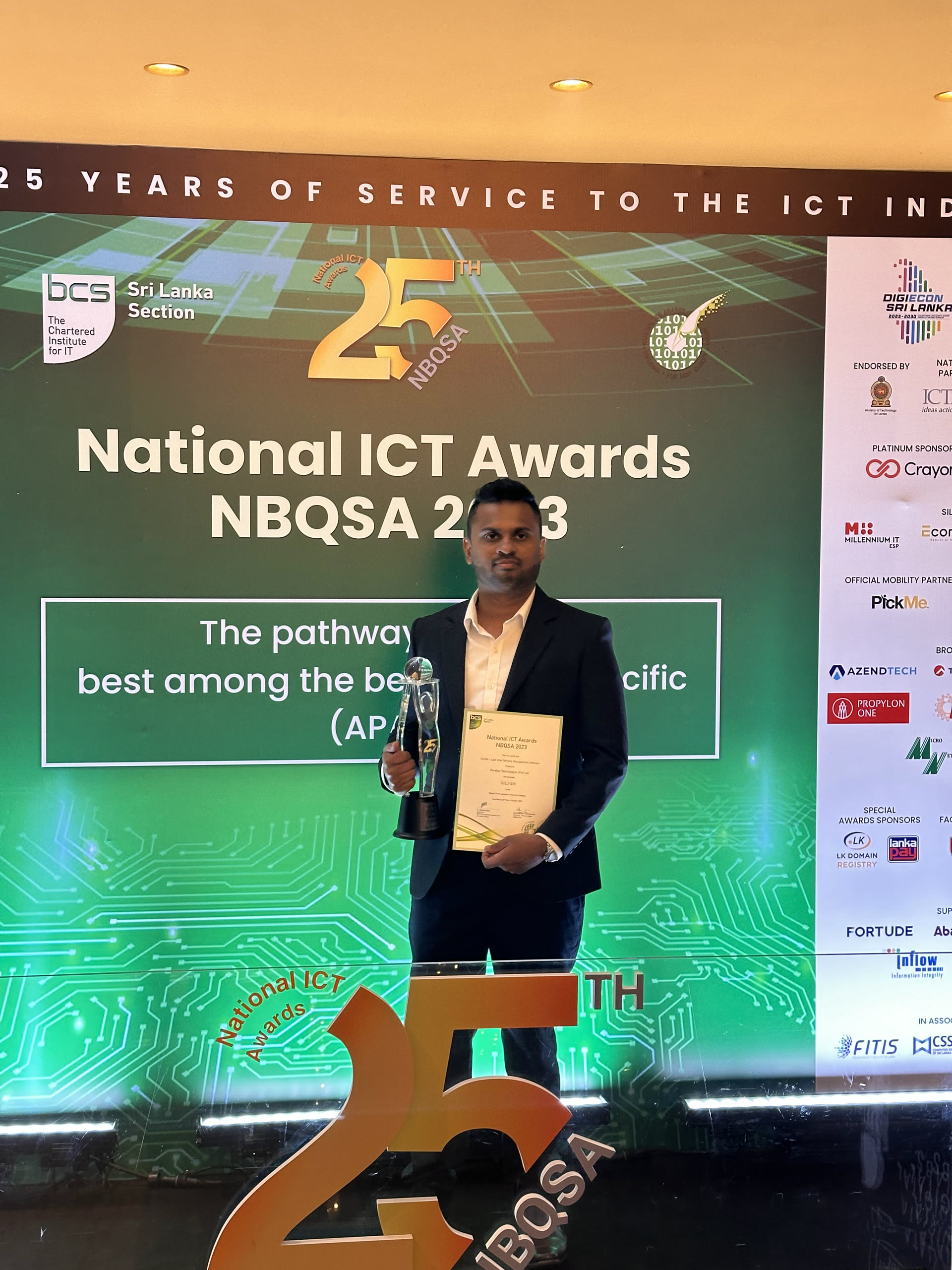Namal Attanayake holding the NBQSA 2023 trophy and certificate on stage