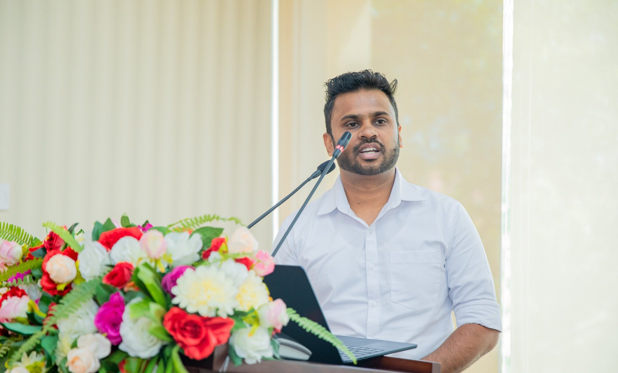 Namal Attanayake speaking at a lectern at Uva Wellassa University